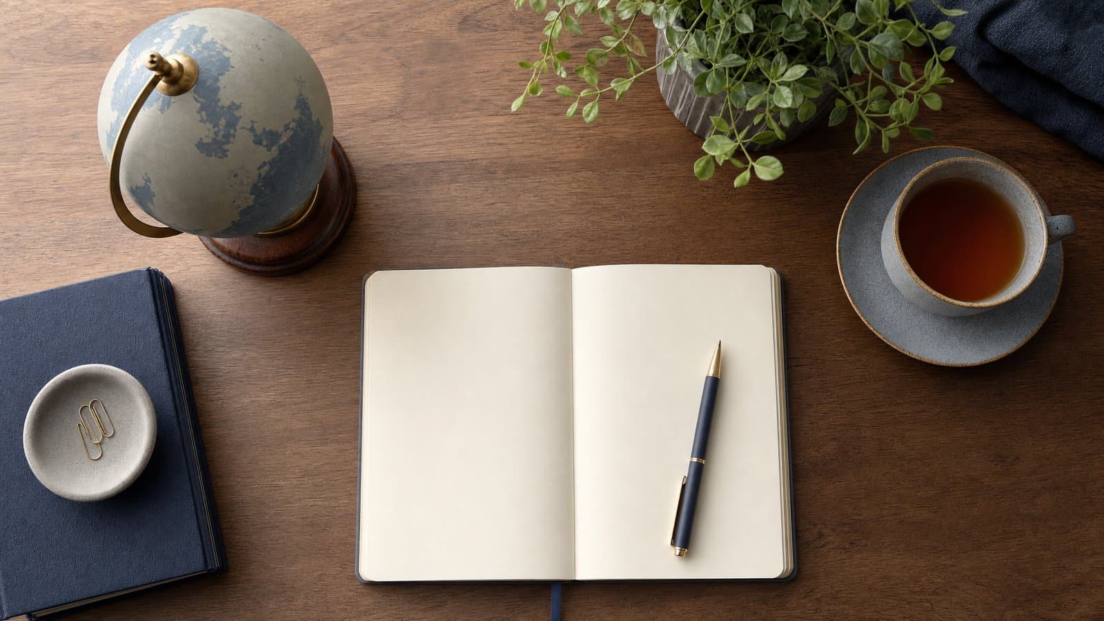 A blank notebook and desk globe — mapping nationalities, residences, and assets before choosing a divorce forum